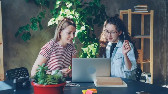 Zwei Menschen schauen gemeinsam auf einen Laptop